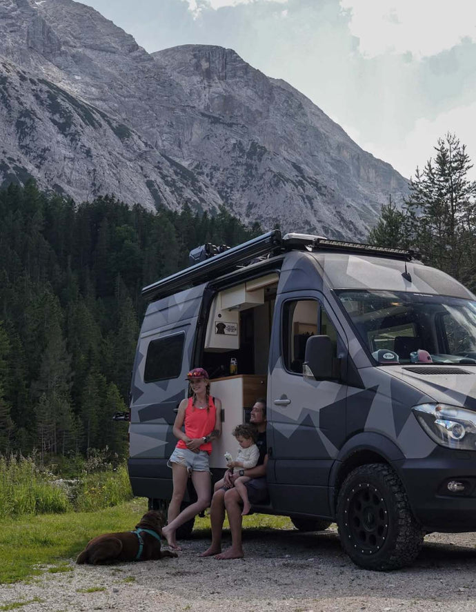 family in their van in front of mountain